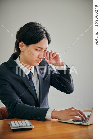 目がかゆくて指でこする若い男性会社員 目がかゆくて指でこする若い男性会社員 108960249