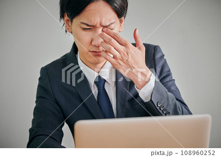 目がかゆくて指でこする若い男性会社員 目がかゆくて指でこする若い男性会社員 108960252