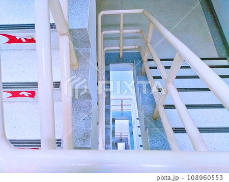 A spiral staircase in a fire escape in a tall building. 108960553
