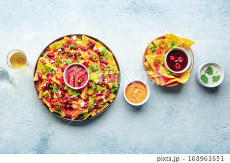 Loaded nachos. Mexican nacho chips with beef, overhead flat lay shot Loaded nachos. Mexican nacho chips with beef, overhead flat lay shot 108961651