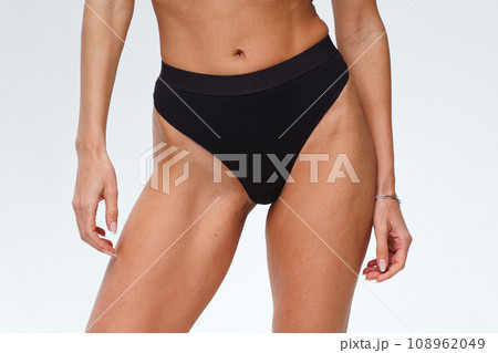 A woman with a beautiful feminine figure in black lingerie with overweight, cellulite and stretch marks.  108962049