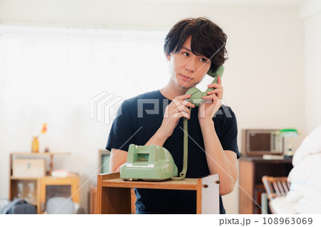 固定電話で電話をする若い男性 固定電話で電話をする若い男性 108963069