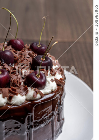 サクランボをのせたチョコレートケーキ 108963965