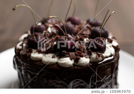 サクランボをのせたチョコレートケーキ 108963970