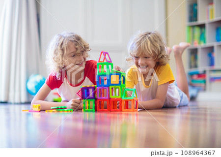 Child playing with magnetic building blocks. 108964367