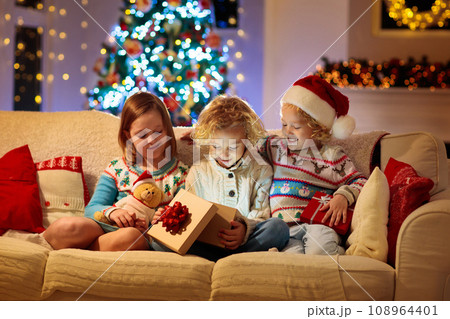 Child at Christmas tree. Kids at fireplace on Xmas 108964401