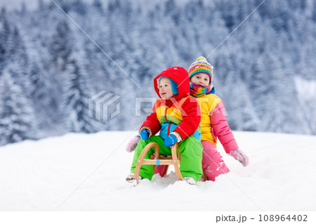Kids play in snow. Winter sleigh ride for children 108964402