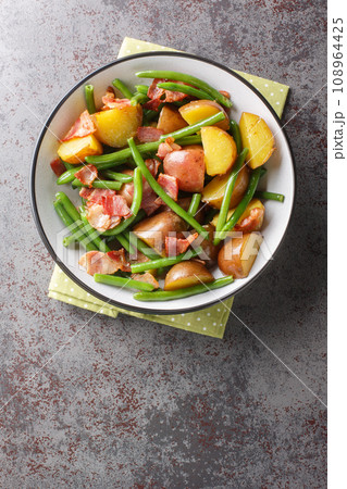 Jacket potatoes with bacon and green beans close-up in a bowl. Vertical top view 108964425
