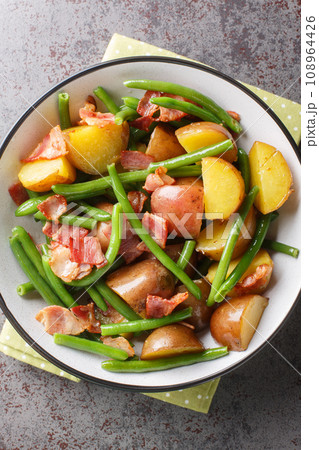 Salade Liegeoise Belgian Potato Salad is a warm potato salad with green beans, bacon and a mustard vinaigrette closeup on the plate. Vertical top view Salade Liegeoise Belgian Potato Salad is a warm potato salad with green beans, bacon and a mustard vinaigrette closeup on the plate. Vertical top view 108964426