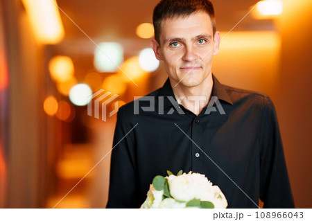 A groom with a bouquet in a long corridor is waiting for the bride. A groom with a bouquet in a long corridor is waiting for the bride. 108966043