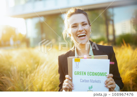 Portrait of happy modern woman worker near business center Portrait of happy modern woman worker near business center 108967476