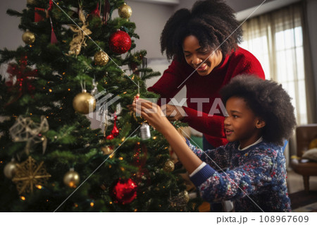 African American mom and daughter decorate a Christmas tree together African American mom and daughter decorate a Christmas tree together 108967609
