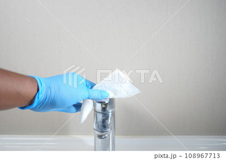 hand in gloves cleaning tap and washbasin, 108967713