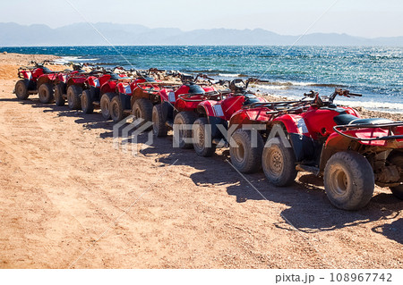 Red quads stand in a row on the shore of the Red Sea. Dahab, Egypt. 108967742