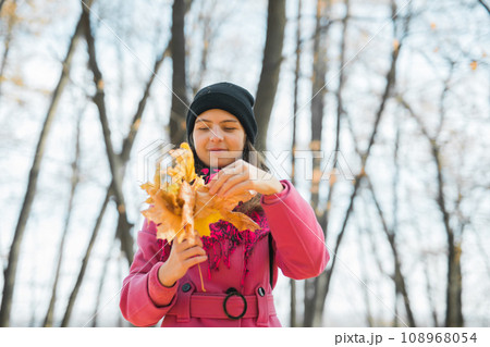 Young woman in a hat collects autumn leaves. Fall season concept. Generation Z and gen z youth 108968054