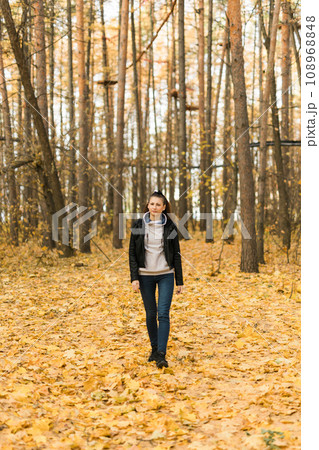 Outdoor atmospheric lifestyle portrait of young beautiful young woman copy space. Warm autumn fall season. Millennial generation and youth 108968848
