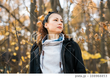 Outdoor atmospheric lifestyle portrait of young beautiful young woman copy space. Warm autumn fall season. Millennial generation and youth 108968853