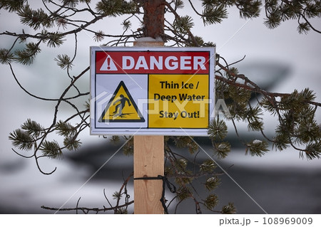 Thin ice warning sign post in winter 108969009