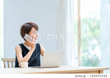 リビングでテレワークをする女性。 108970588
