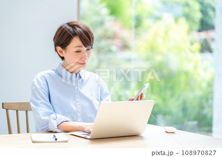 リビングでテレワークをする女性。 108970827