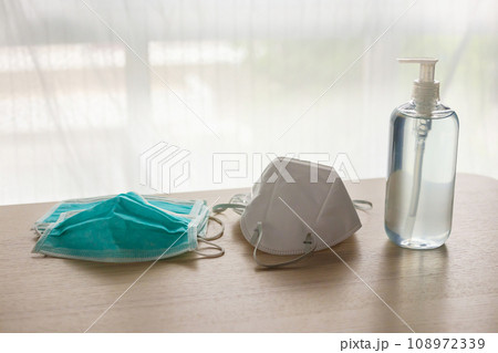 Medical face mask with alcohol sanitizer gel hand wash on wood table for covid-19 Coronavirus prevention concept Medical face mask with alcohol sanitizer gel hand wash on wood table for covid-19 Coronavirus prevention concept 108972339