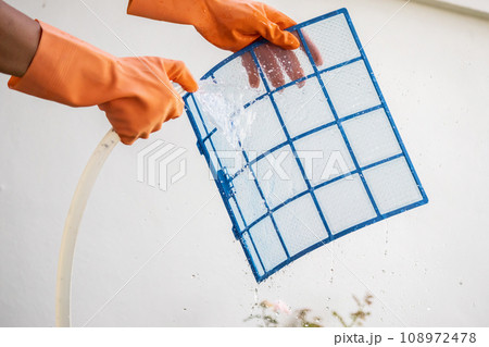 Asian man cleaning air conditioner dirty filter 108972478