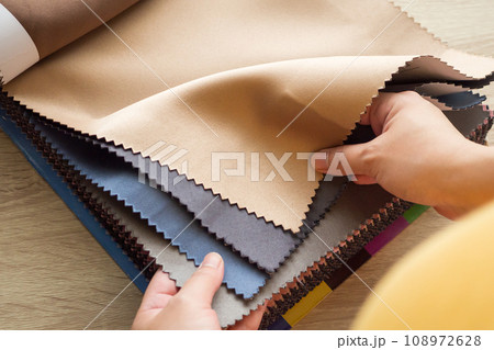 female designer with fabric color samples choosing textile for curtains female designer with fabric color samples choosing textile for curtains 108972628