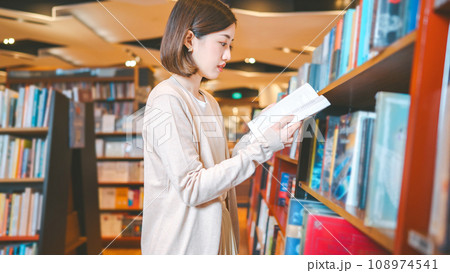 Portrait of young adult southeast asian woman reading book at bookstore shop Portrait of young adult southeast asian woman reading book at bookstore shop 108974541