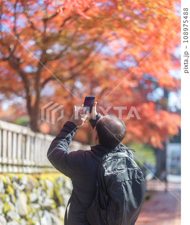紅葉を撮影する男性 108975488