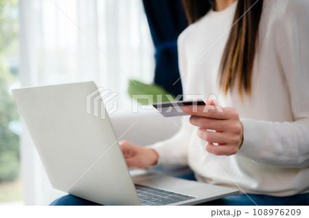 Young asian woman sitting on sofa in living room 108976209