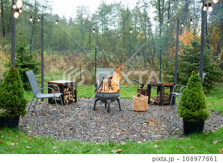 Fire pit and burning fire in a garden Fire pit and burning fire in a garden 108977861