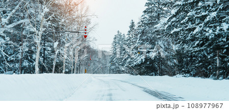 Beautiful snow road forest view during car driving in winter season. Winter travel, Road trip, Adventure, Exploring and Vacation concepts Beautiful snow road forest view during car driving in winter season. Winter travel, Road trip, Adventure, Exploring and Vacation concepts 108977967