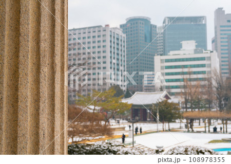 Snowy winter Deoksugung Palace and office buildings in Seoul, Korea 108978355