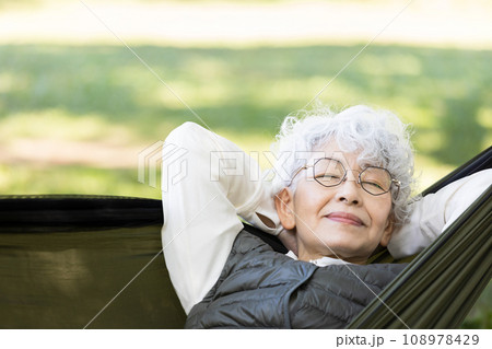 ハンモックでくつろぐ60代女性 108978429