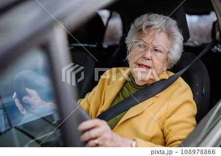 Focused senior woman driving car alone, enjoying car ride. Safe driving for elderly adults, older driver safety. 108978866