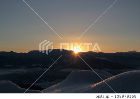 冬の斑尾高原からみる志賀高原の山々から登る朝日 冬の斑尾高原からみる志賀高原の山々から登る朝日 108979369