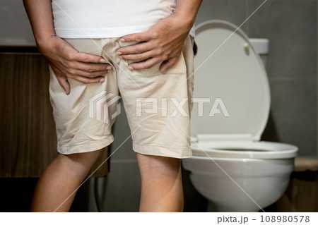 Man having haemorrhoids hold his bottom,painful and swollen in the region of the anus,hemorrhoid were acting up,anal pain,hemorrhoids from symptoms of constipation or diarrhea,health problem concept 108980578