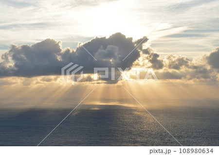 曇り空の中で海に沈んでいく夕日 曇り空の中で海に沈んでいく夕日 108980634