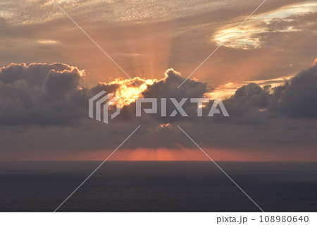 曇り空の中で海に沈んでいく夕日 曇り空の中で海に沈んでいく夕日 108980640