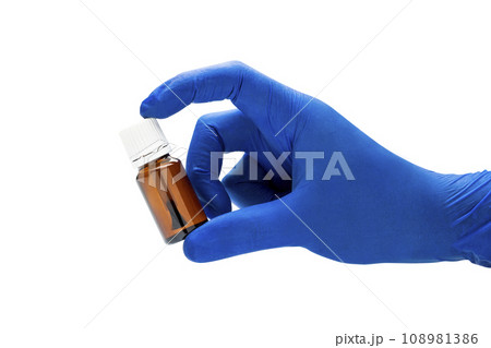 Hand with medical glove holding pill bottle 108981386