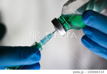 Physician injector arms in sterile uniform holding syringe Physician injector arms in sterile uniform holding syringe 108986314