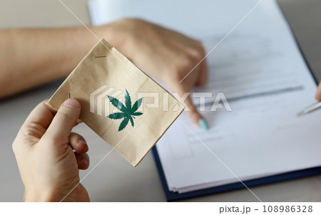 Male arm holding paper packet Male arm holding paper packet 108986328