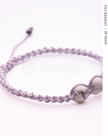 Tibetan Dzi bead. Cacholong Dzi bead Luck hook bracelet. Bracelet made of stones on hand from natural stone Cacholong. Bracelet made of natural stones. Handmade bracelets on black modern background. 108986782