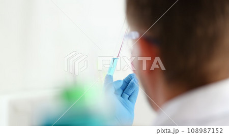 A male chemist holds test tube of glass A male chemist holds test tube of glass 108987152