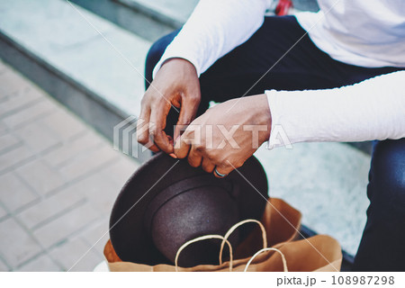 cropped image of african american male shopaholic resting on stairs after shopping time cropped image of african american male shopaholic resting on stairs after shopping time 108987298