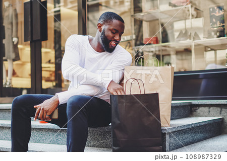 positive african american male happy about buying clothing in wear store with good discount positive african american male happy about buying clothing in wear store with good discount 108987329