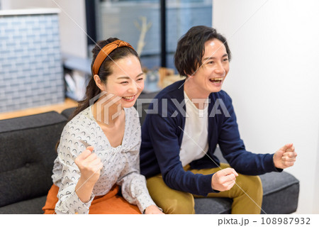 ソファーで応援する男女 ソファーで応援する男女 108987932