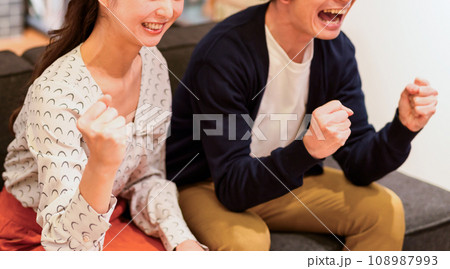 ソファーで応援する男女 ソファーで応援する男女 108987993