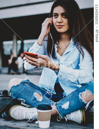Charming young woman enjoying playlist from cellular 108988453