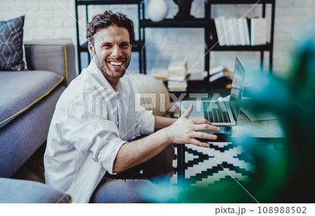 Cheerful caucasian male freelancer enjoying distance job in modern interior apartment 108988502